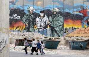 Children walk in front of a mural in Bethlehem, ahead of Nakba