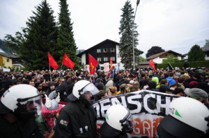 Policemen walk alongside a rally of anti G7-protesters in Garmisch-Partenkirchen, southern Germany on June 6, 2015, ahead of the G7 summit. Germany will host the G7 summit at Elmau Castle on June 7 and June 8, 2015. AFP PHOTO / ROBERT MICHAEL